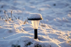 snowy solar garden lamp in winter time