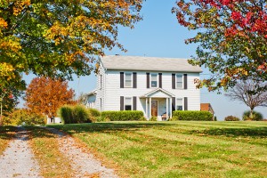 Two story white wood siding farm house in USA in autumn.